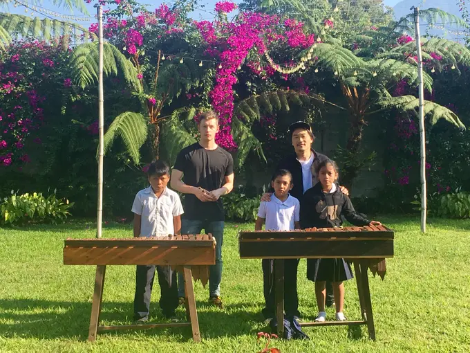Visitantes y ninos junto a marimbas en el jardin