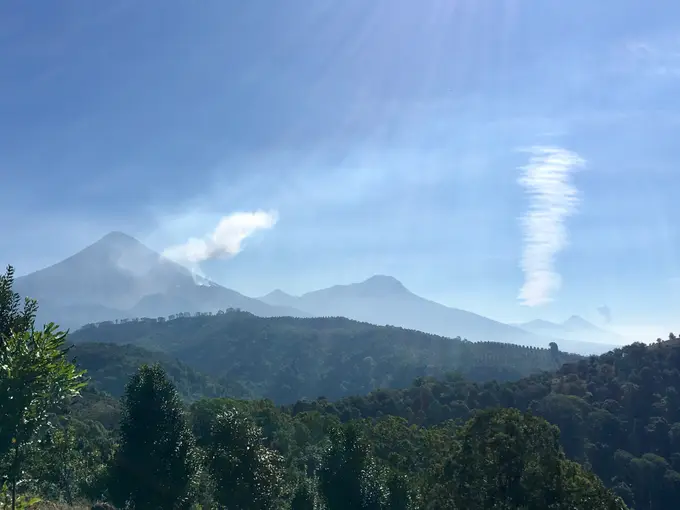 Volcan Santiaguito con fumarola entre montanas