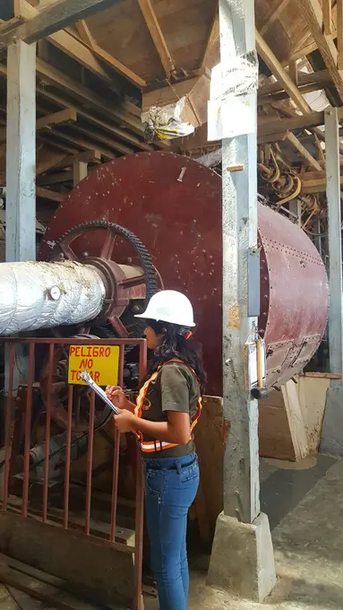 Trabajadora revisando molino del beneficio de cafe